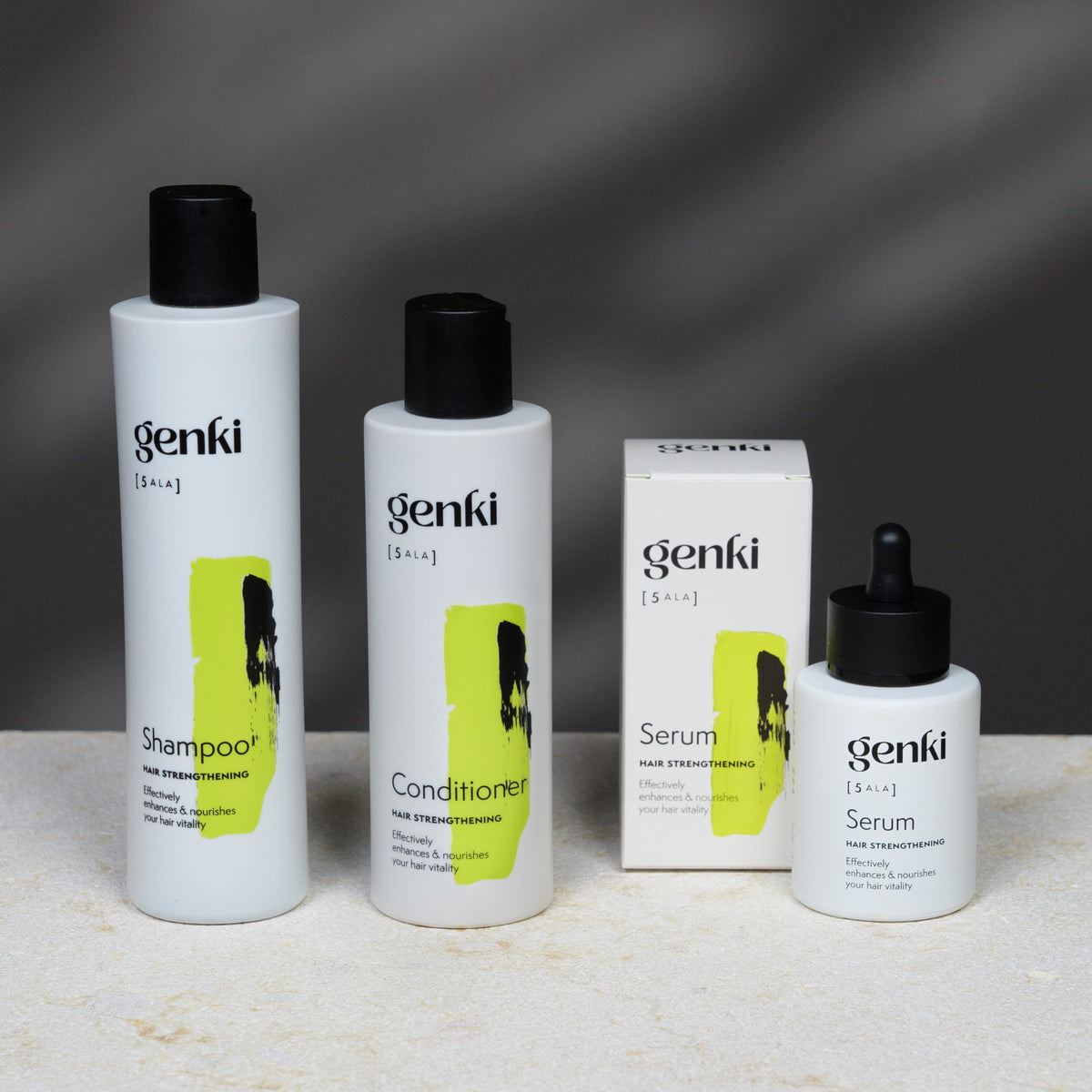 genki Hair Strengthening Set mit Shampoo, Conditioner und Serum vor dunklem Hintergrund